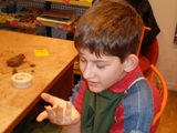 A young visually impaired student working with clay
